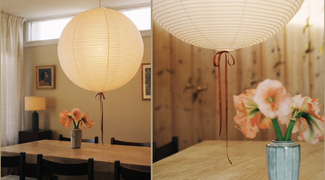 dining room with big rice paper shade with a christmasy detail, a long ribbon bow under