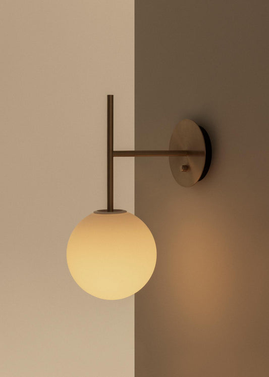 Vegglampen TR Suspended Wall Lamp fra Audo Copenhagen er designet av Tim Rundle, som er kjent for å skape møbler og lamper som kombinerer funksjon og estetikk på vakkert vis. 