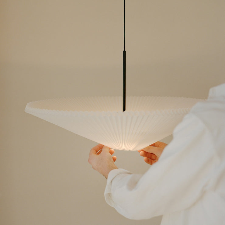 Taklampen Nebra Pendant Lamp fra New Works kombinerer klassisk design med funksjonalitet på poetisk vis: Den plisserte lampeskjermen er justerbar for å kunne tilpasses etter varierende lysbehov året gjennom og hvilken stemning man ønsker å skape i rommet – med et enkelt grep kan du 'vrenge' skjermen og velge om du vil kaste lyset oppover, nedover eller begge deler samtidig. Smart – og fint!